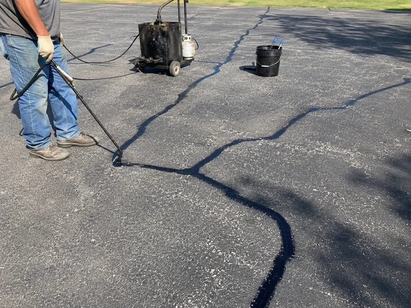 Hot rubber crack sealing on asphalt pavement in Lafayette